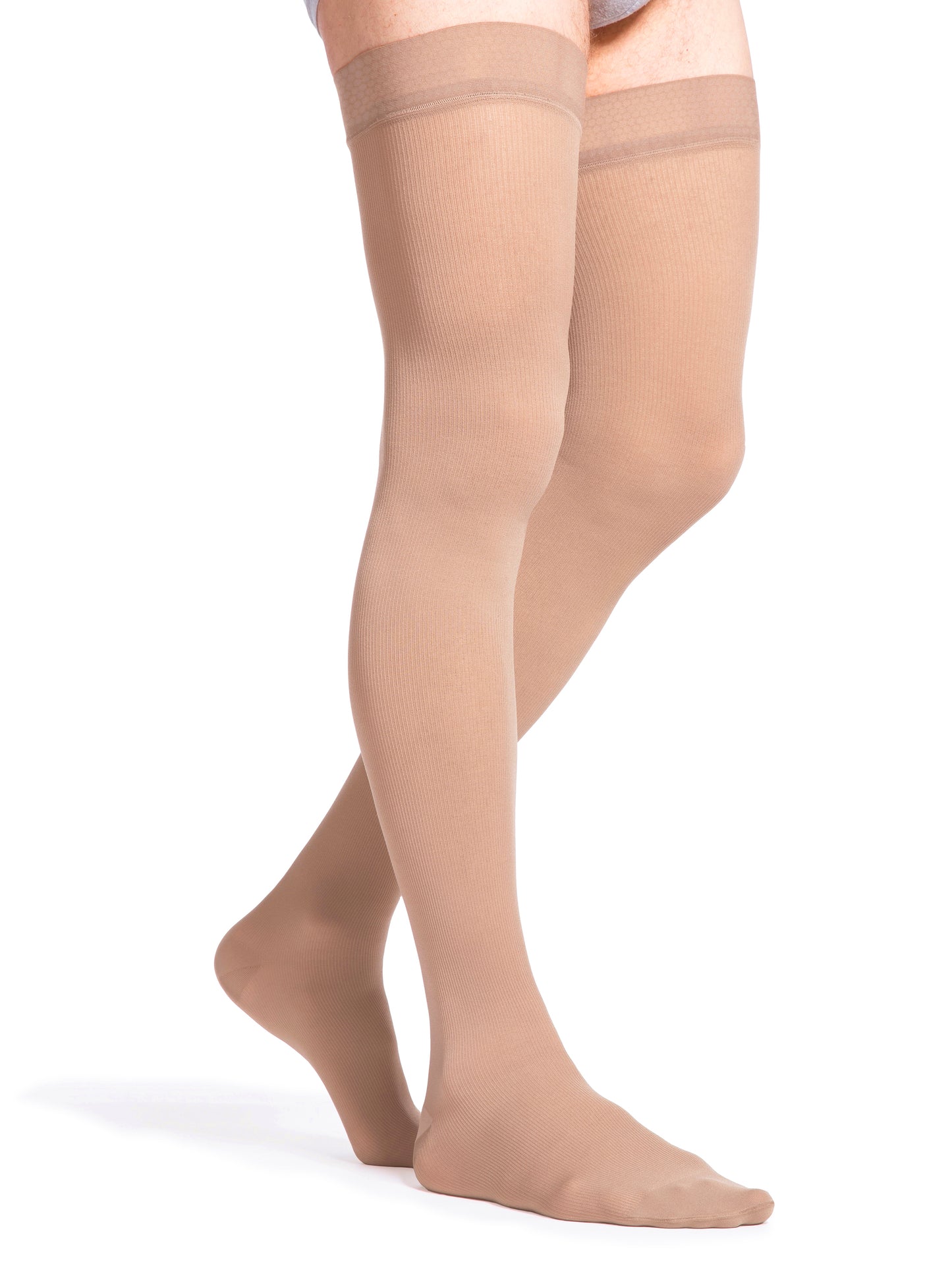 Man wearing Sigvaris Men's Essential Opaque compression thigh-highs in the color Light Beige