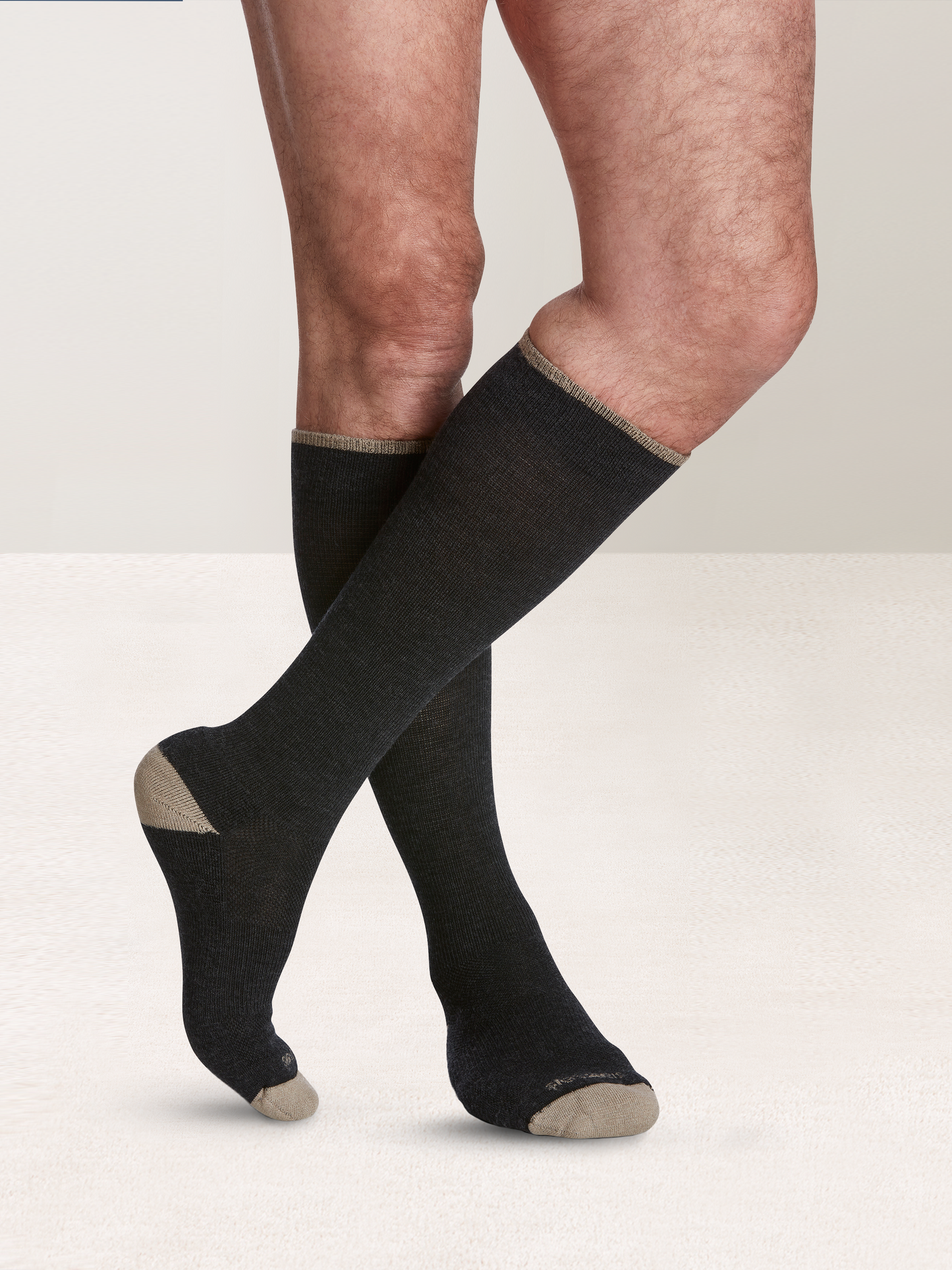 Man wearing Sigvaris Men's Motion Thermoregulating Wool compression socks in the color Charcoal