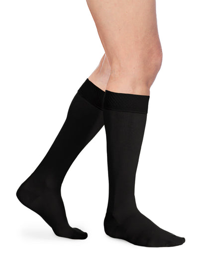 Man wearing Sigvaris Men's Essential Opaque calf plus with grip-top in the color Black