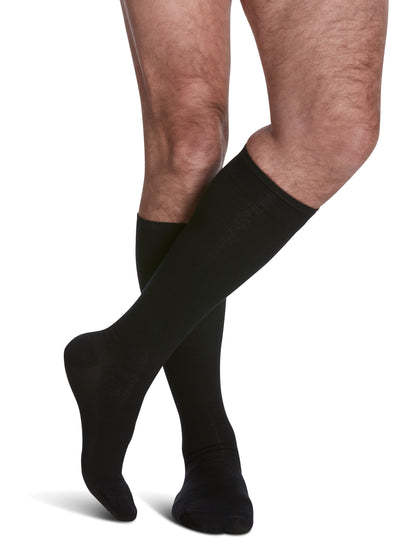 Man wearing Men's All-Season Merino Wool Calf compression socks in the color Black