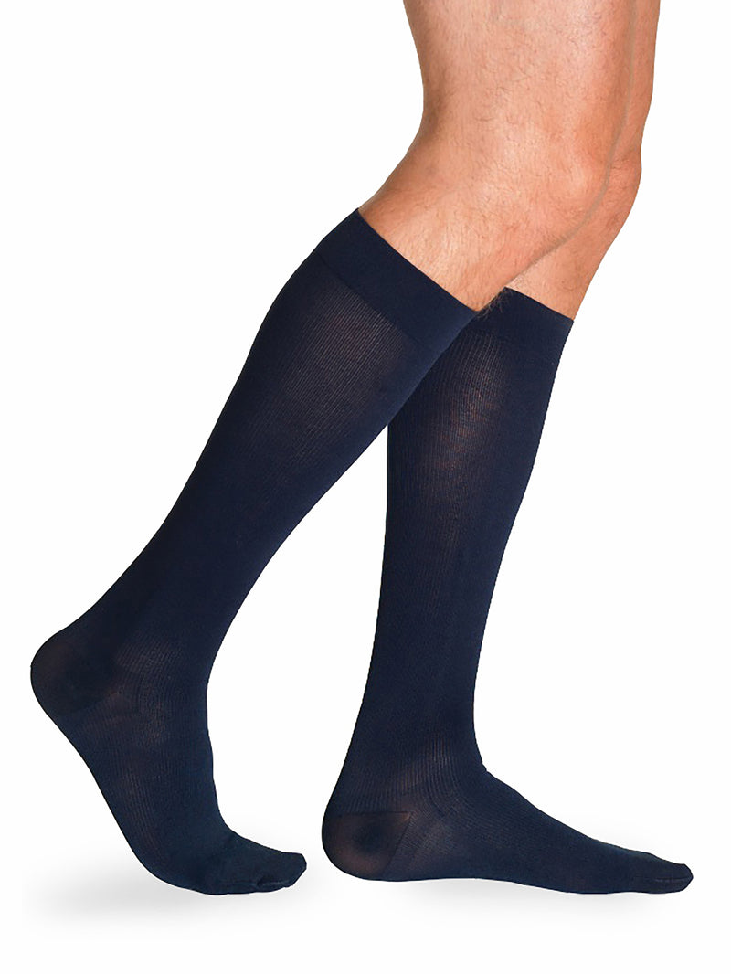 Man wearing Sigvaris Men's Essential Cotton compression socks in the color Navy