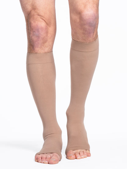 Man wearing Sigvaris Essential Cotton Open-Toe compression stockings in the color Light Beige