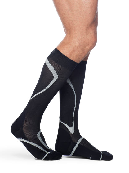 Man wearing Sigvaris Men's Motion High-Tech compression socks in the color Black