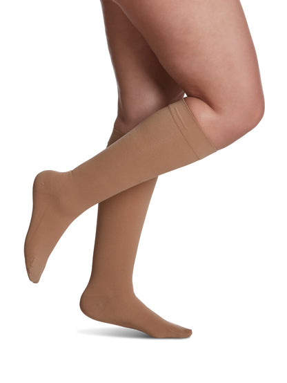 Woman wearing Sigvaris Women's Essential Cotton compression socks in the color Light Beige